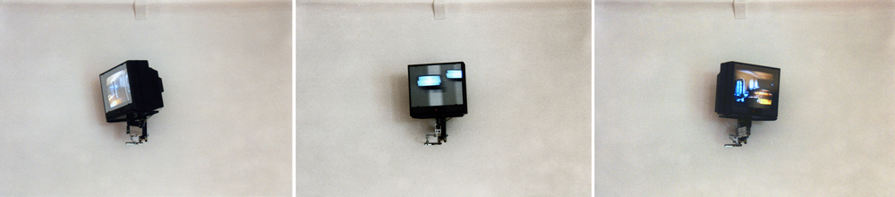 Art, artwork. An installation entitled "Reflex" by Nika Span / Nika Špan. Material: VHS player, VHS cassette (245 minutes), a video projector, a TV stand, a television set, a two-way mirror, an electric motor. Exhibition: SIQ 1999, WUK, Kunsthalle Exnergasse, Vienna, Austria. 